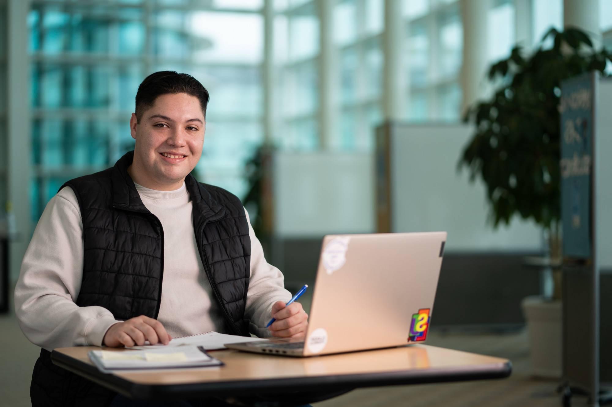 Student sitting at a desk with a laptop open